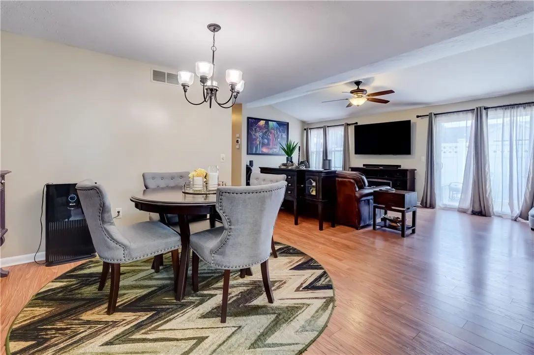 Dining area open to living room with cathedral ceiling