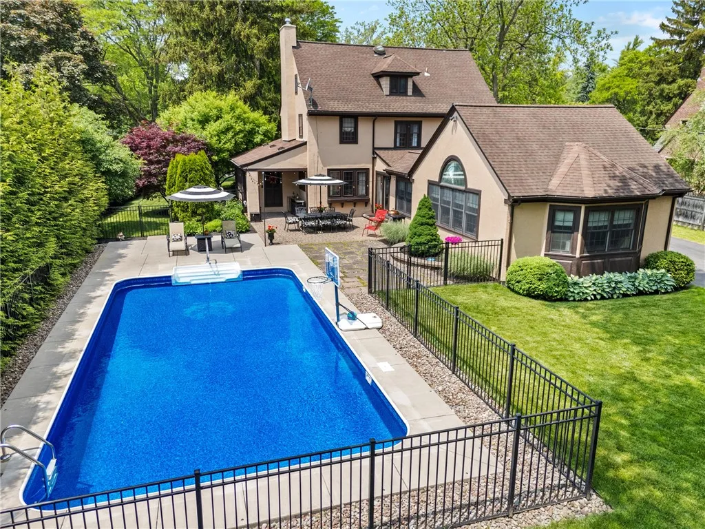 Surrounded by lush evergreens and a secure fence, it offers both privacy and fun, making it ideal for water sports and outdoor entertaining.