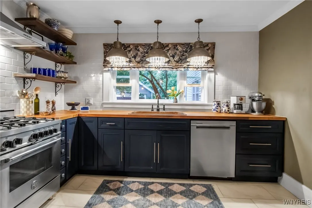 Wall of windows above sink overlooking park-like yard