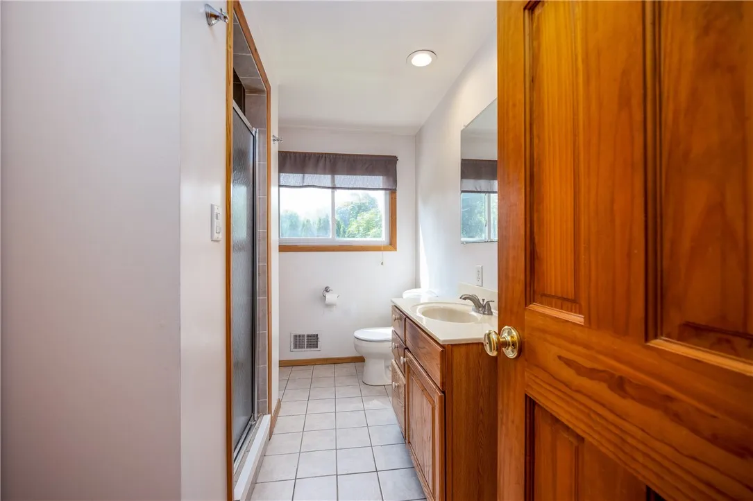 Main bath with full lighted shower- there are tons of built-in oak cabinetry!