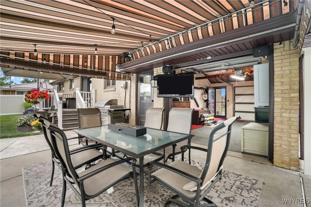 Attached Garage with Front & Back Doors Opening Up to the Concrete Patio with Awning