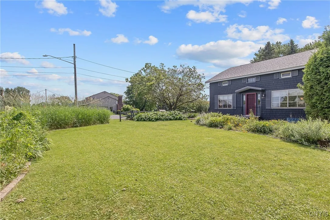 And just look at the massive front yard of this beautiful corner lot, complete with gardens, shrubbery, and trees offering lots of privacy.