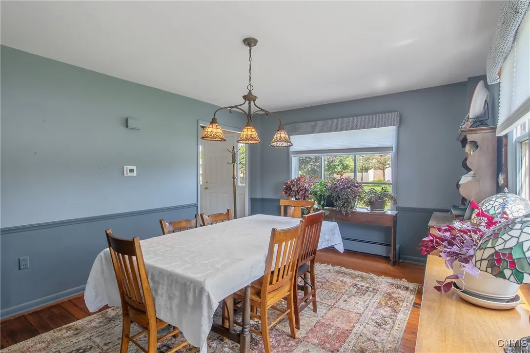 The other side of the dining room shows the doorway leading to the front door, stairs, and living room.