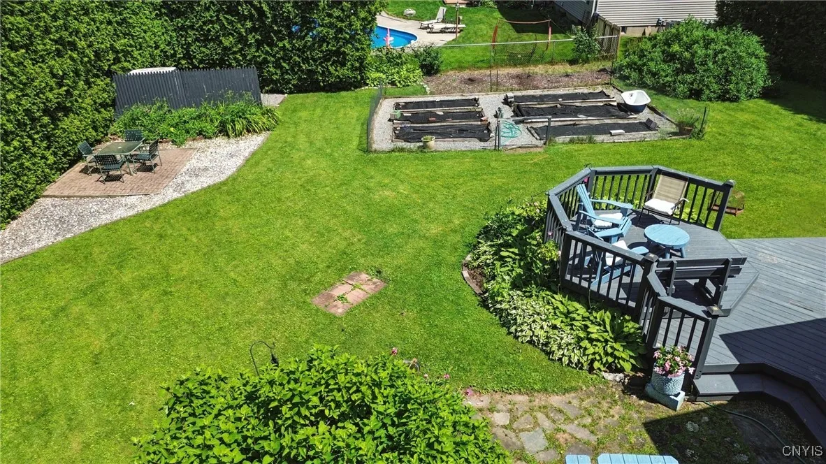 A birds-eye view of the backyard showing seating areas and a vegetable garden ready for planting.