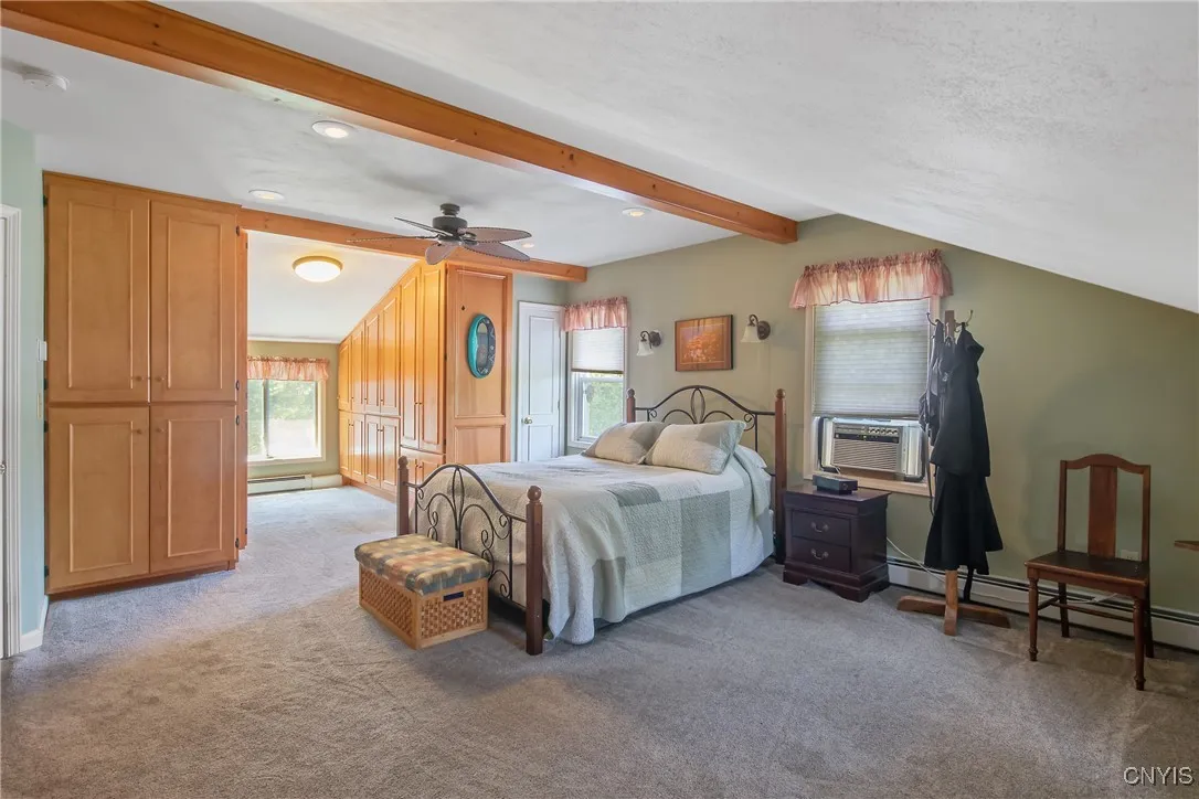 Heading upstairs, we step into this huge primary bedroom where you will find custom built-in closets and drawers. You will be amazed by the amount of space in this room!