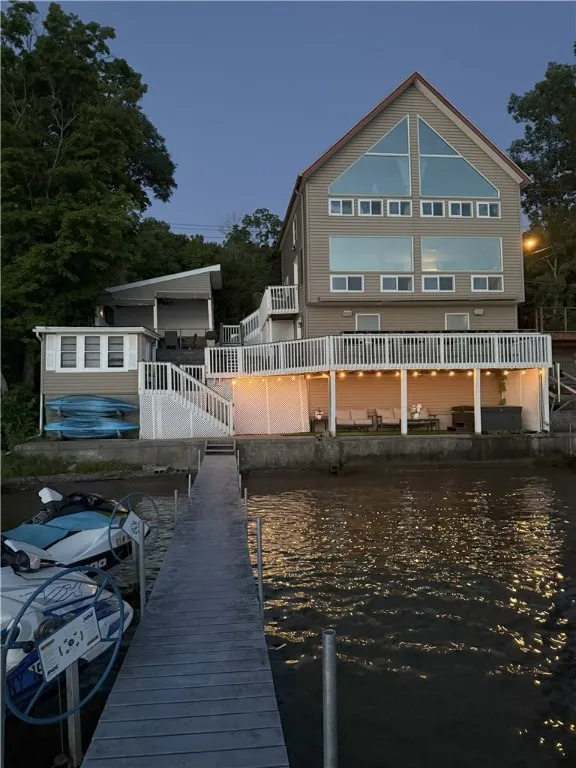 View of home at dusk showing the bunk house, new deck and pavillion.