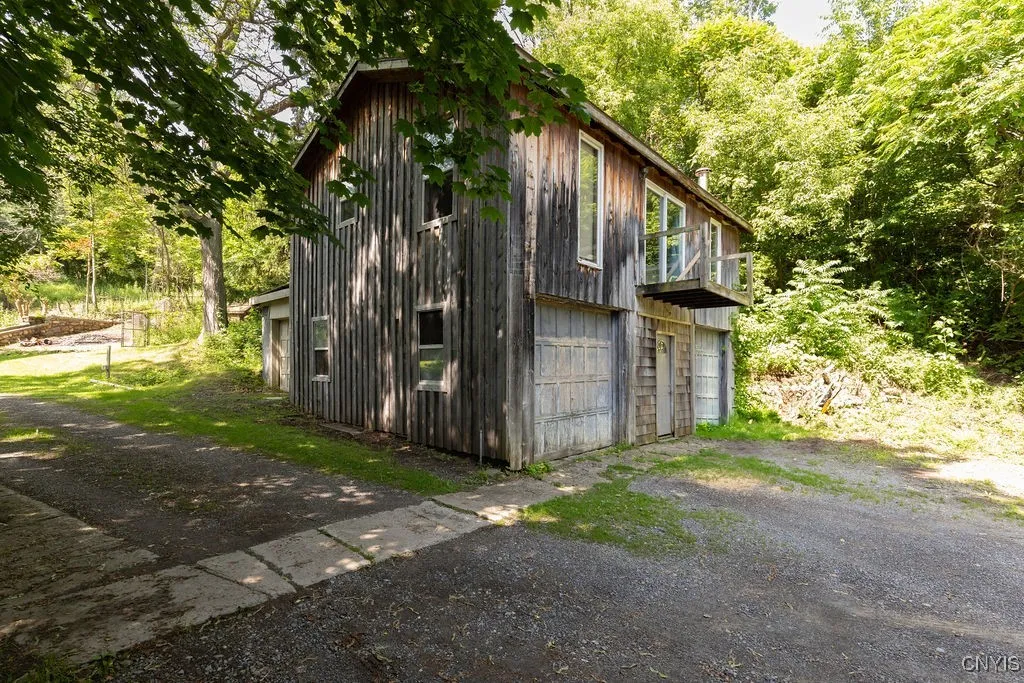 There\'s a 2-story garage that is currently used for storage. You could easily fit two cars in with plenty of extra room. Upstairs once housed an efficiency unit with a full bathroom, kitchen and living room. It could be brought back but would take some work.