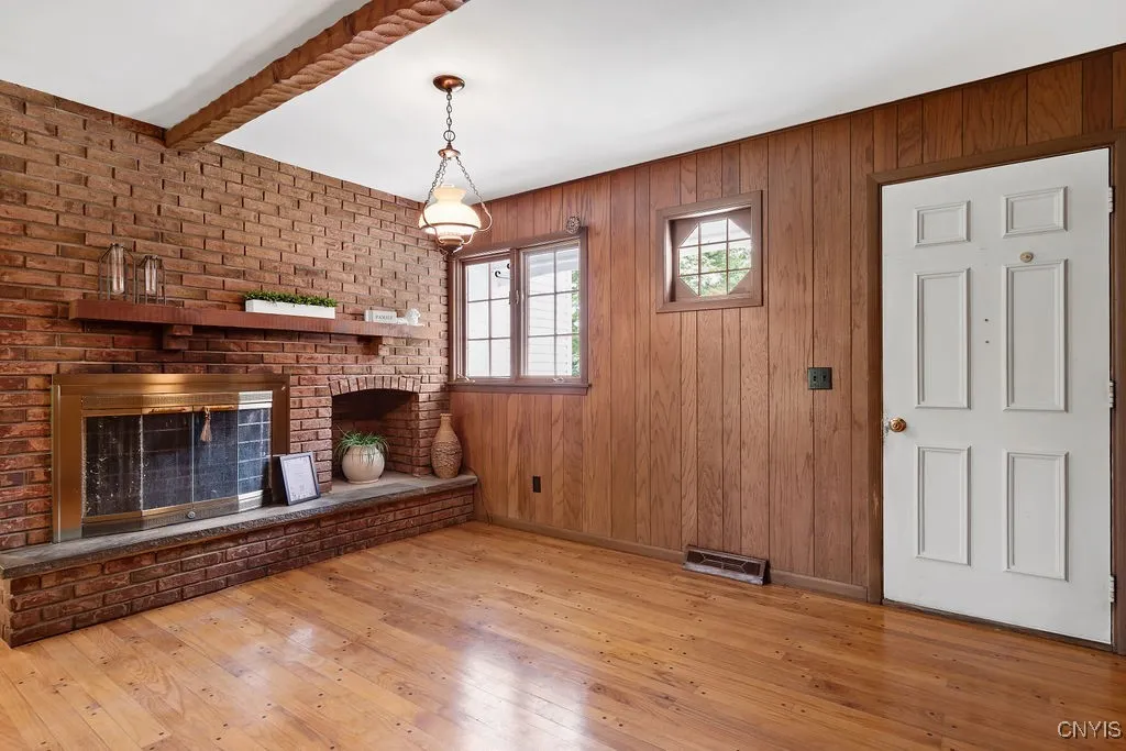 Family room with hardwood floors, stunning brick wood burning fireplace.