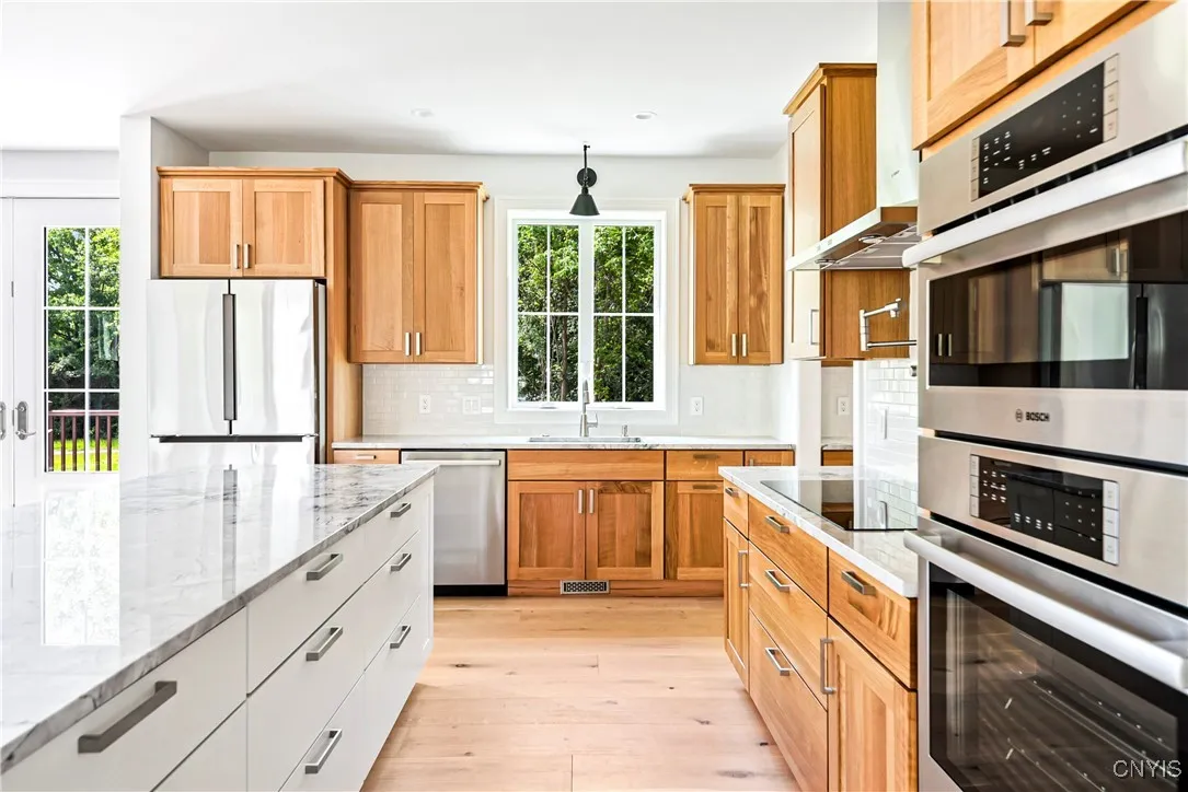 A spacious kitchen with quarter-sawn oak cabinets, a large island, and a pantry to the right.