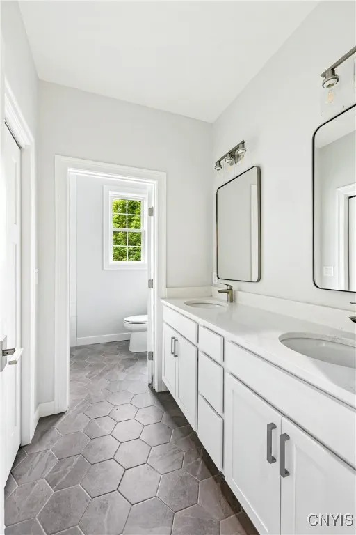 Bath for bedrooms 3 and 4 with spacious vanity, closet and separate room with tub and toilet.