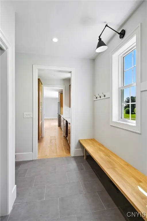 Mud room with sitting bench with pantry ahead and garage to the left.