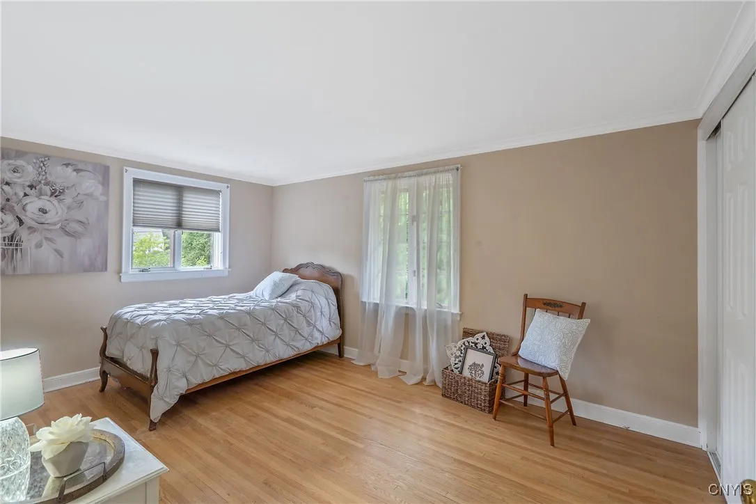 The first of the bedrooms of this level runs along the back of the home with large windows. Sumptuous hardwood floor adorn this level, too!