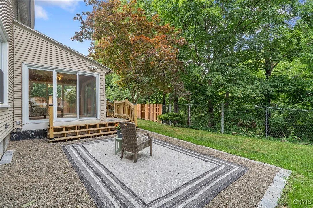 And this pea-stone gravel patio area is the ideal spot to sit with a book and savor the soothing sounds of the bubbling Meadow Brook down the slope behind the fence. Imagine this backdrop when the leaves change color in the fall - just breathtaking!