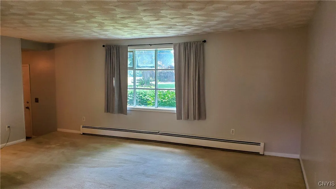   Living room with picture window.  Home has hot water heat.