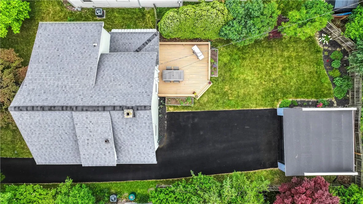 A newly sealed driveway leads to the detached two-car garage, which includes an electric car charger.