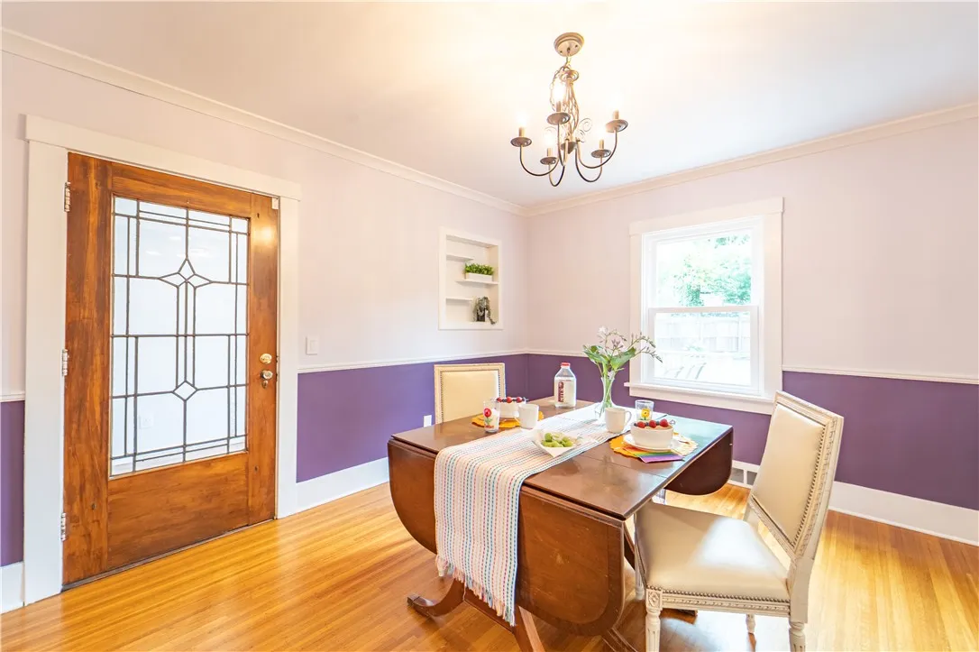 A pop of purple and timeless trim accents, leaded glass door leads to the enclosed sunroom.
