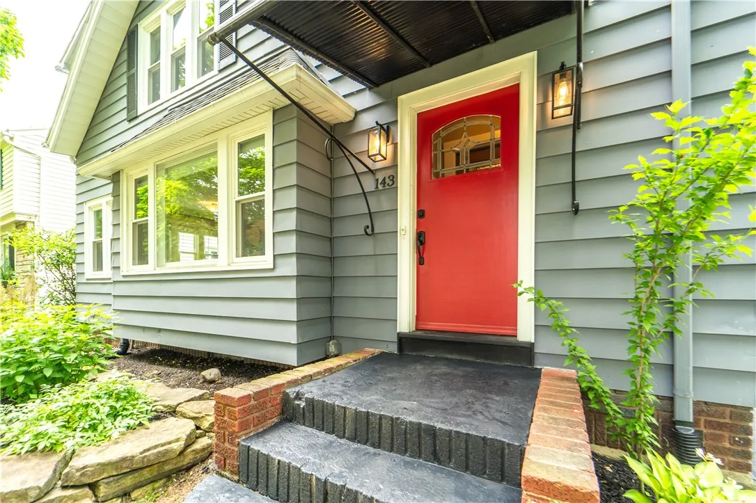 A cheerful red door and brick steps set a welcoming tone.
