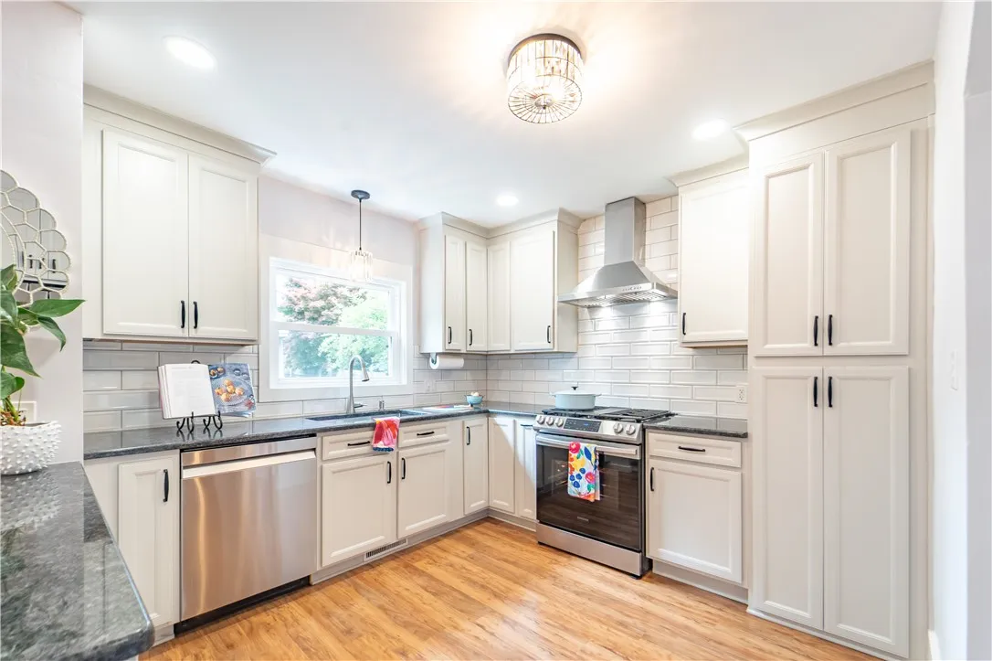 The heart of the home — the updated kitchen — pairs form and function with sleek dark granite countertops, and stainless steel appliances.