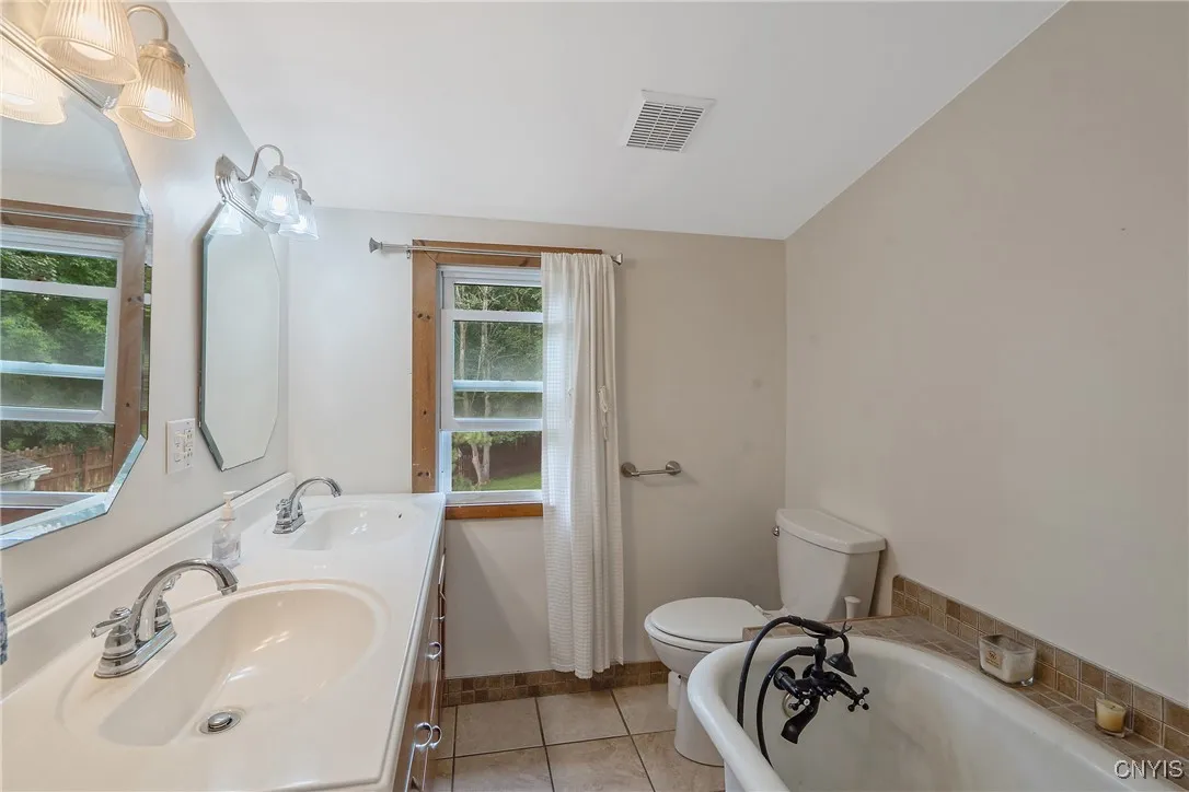 In between the bedrooms upstairs is another full bathroom. Double sinks in the vanity mean lots of room to spread out for your ablutions.  And the old-style soaking tub has been retro-fitted with a shower wand to help the rinse off.