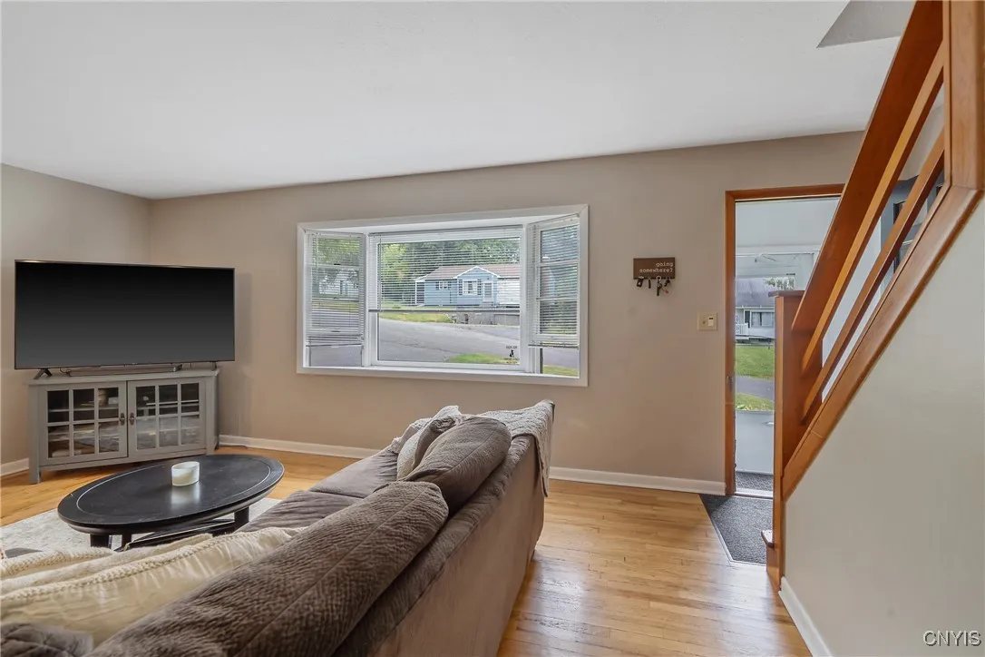 Beyond the vestibule is the spacious family room at the front of the home.  The large bay picture window simply floods the space with natural sunlight. Just look how it gleams on the natural hardwood flooring!