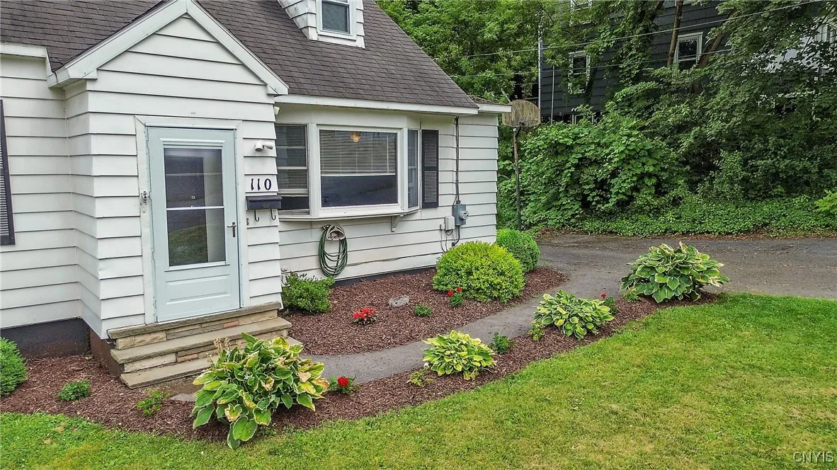 The sweet front walkway has perennial landscaping to add to the charming curb appeal of the house.