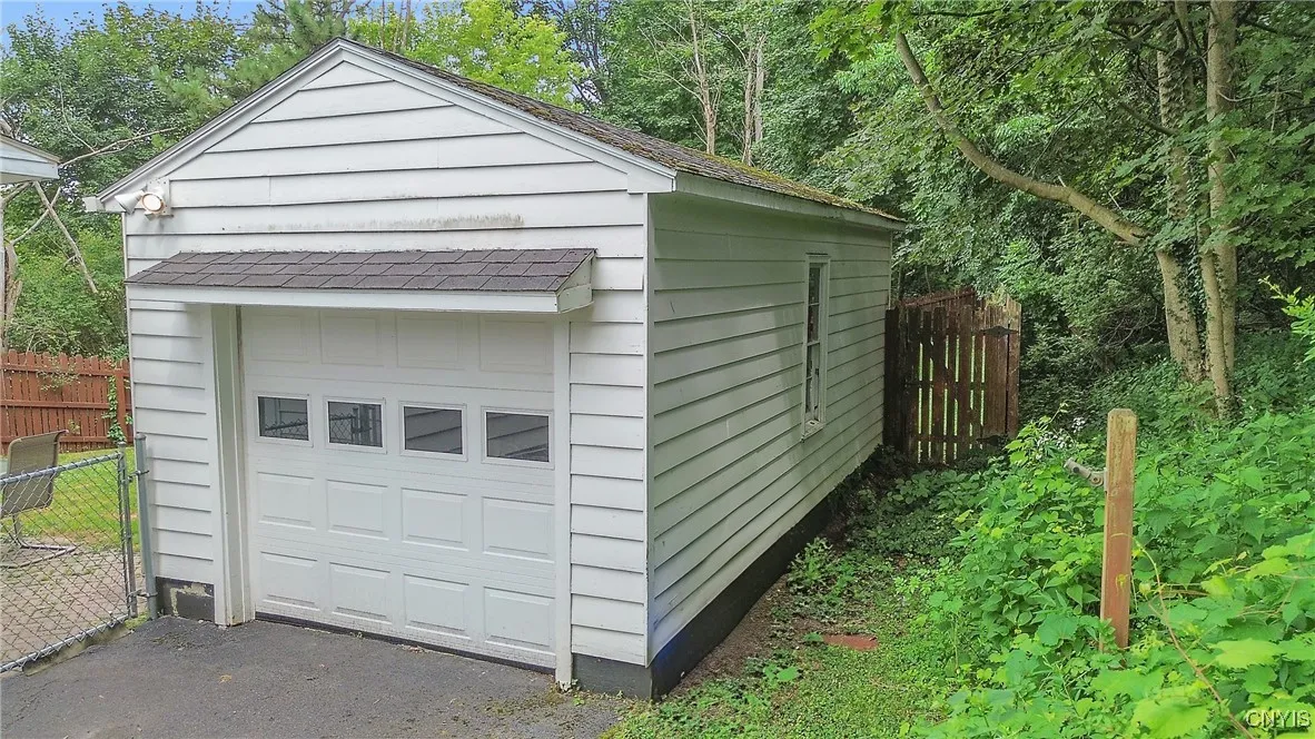 At the end of the driveway, or through the chain-link gate at the patio, access the garage.  There is also a pedestrian door on the other side of the gate so you can enter the garage without opening the overhead door.
