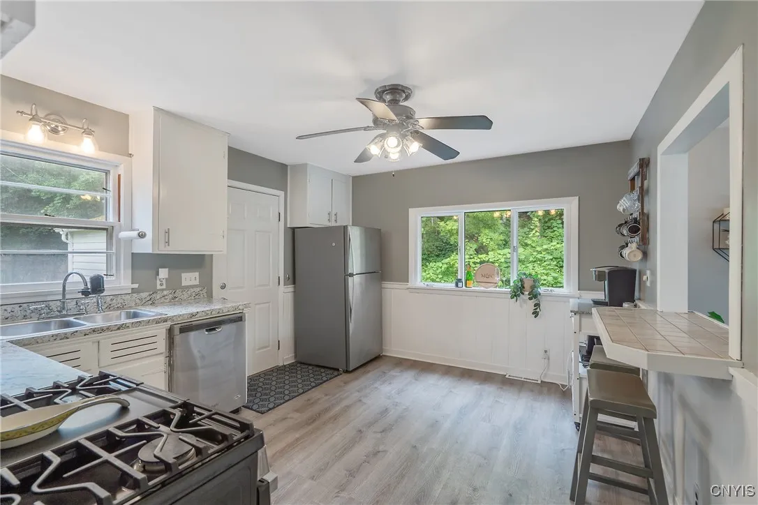 And on the other side, we see into the updated kitchen.  New stainless steel appliances are a wonderful accent to the new countertops and luxury vinyl flooring installed here.