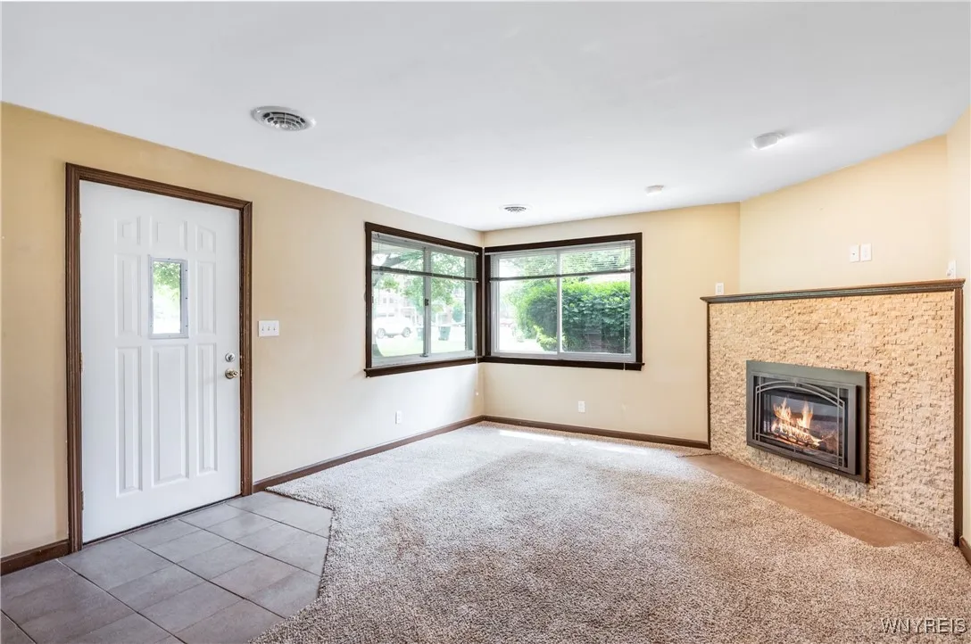 Enter into the family room with a stunning gas fireplace.  The tiled foyer keeps the carpet clean!