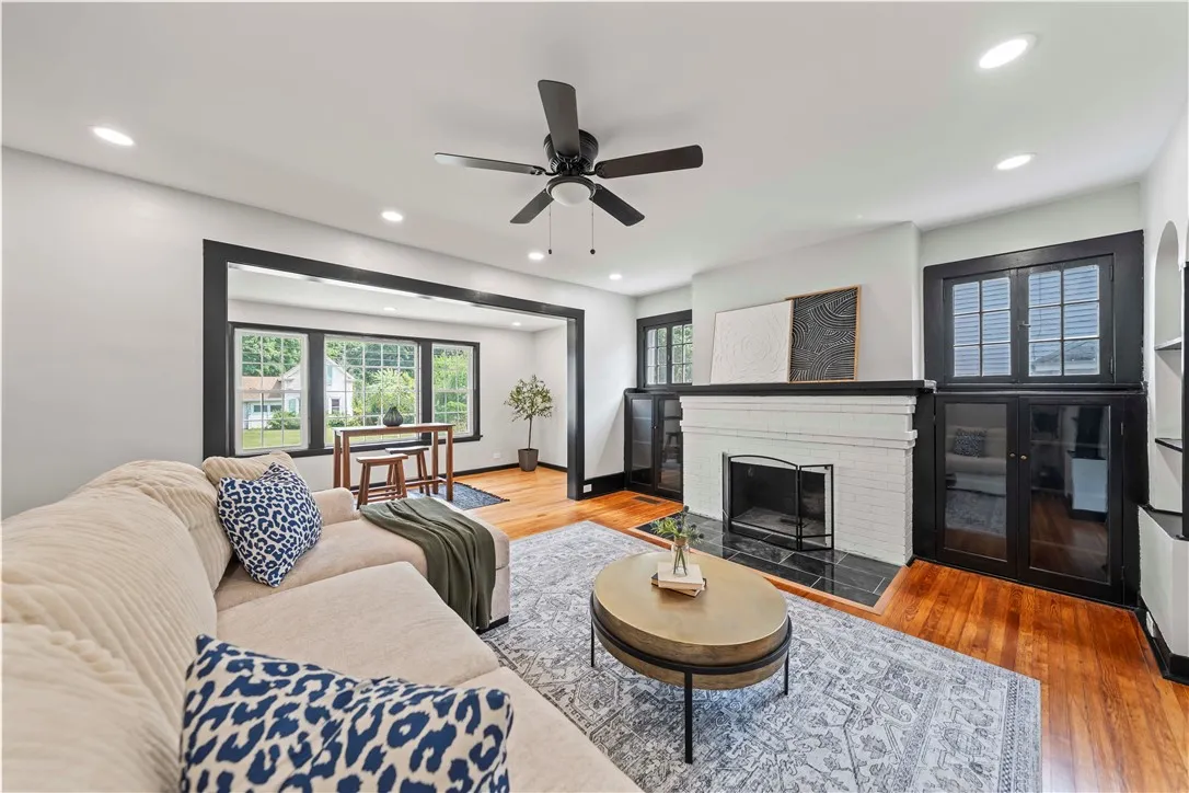 Living room with recessed lighting, wood burning fireplace, and original hardwood floors