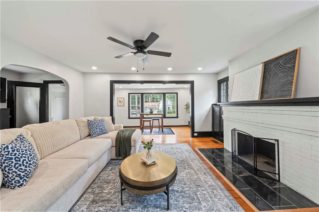 Living room with recessed lighting, wood burning fireplace, and original hardwood floors