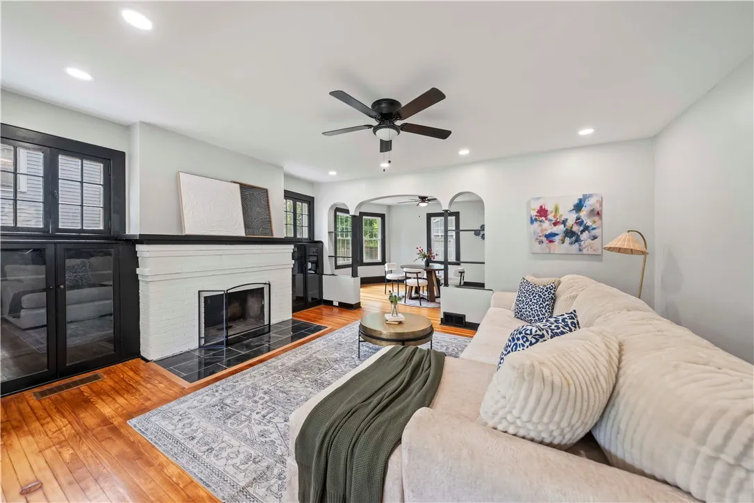 Living room with recessed lighting, wood burning fireplace, original hardwood floors, and built in book cases on both sides of fireplace