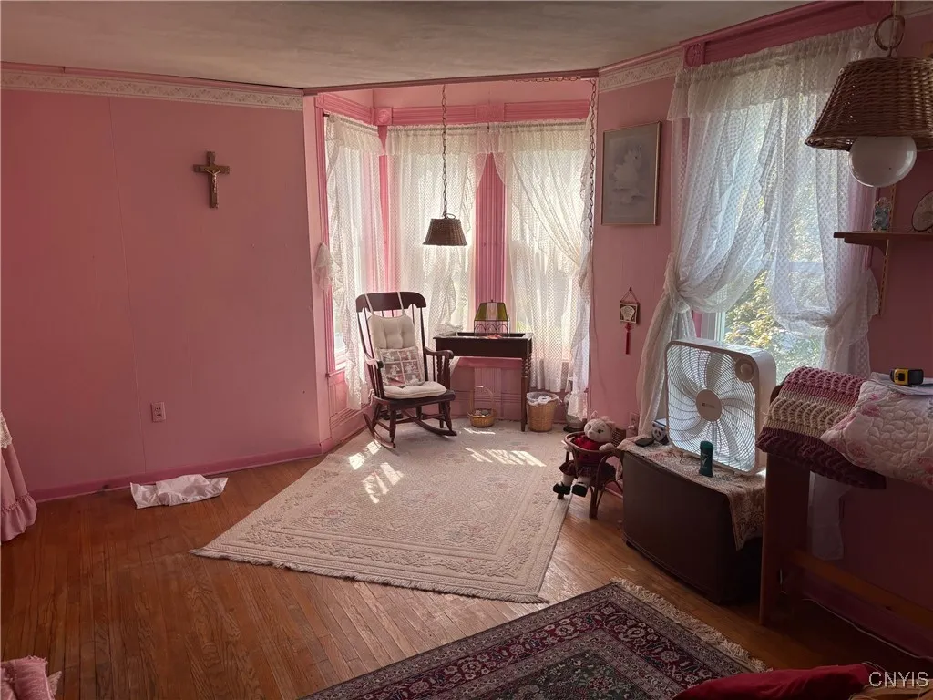 Large sitting area with hardwood floors and nice natural lighting