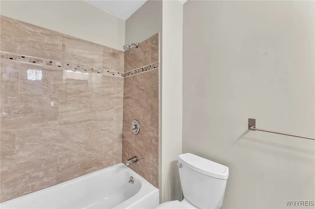 Downstairs full bath. Bath boasts a light fixture with a bluetooth speaker.