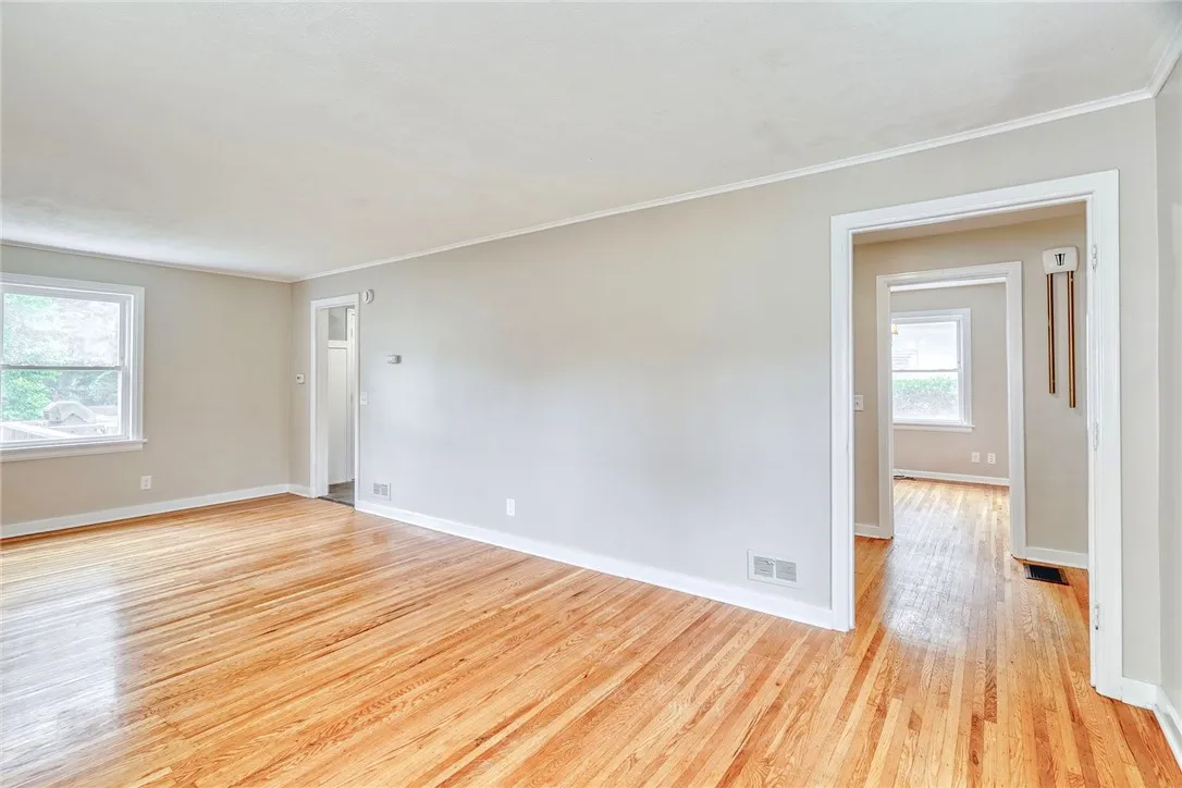 Generous sized living room with gleaming hard wood floors