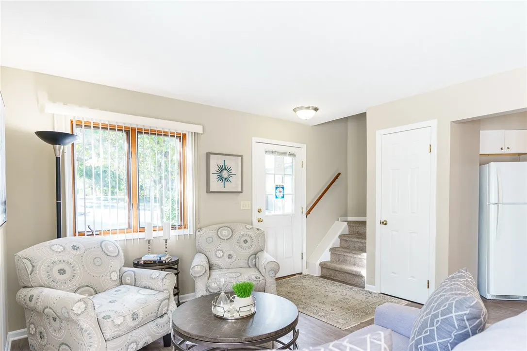 Typical Great Room with faux wood floors (view shows living area, front entrance, stairway, and doorway to kitchen)