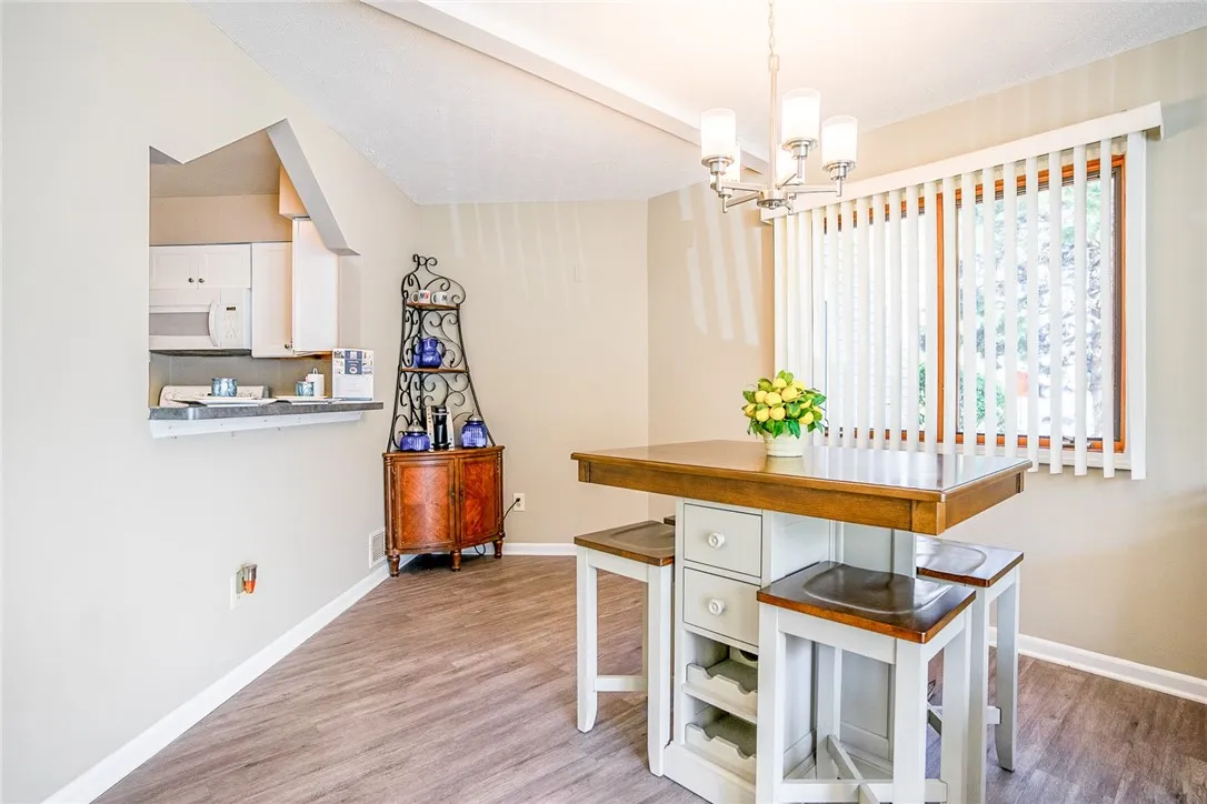 Typical Great Room with faux wood floors (view shows dining area and pass-through/breakfast bar between kitchen and dining area)