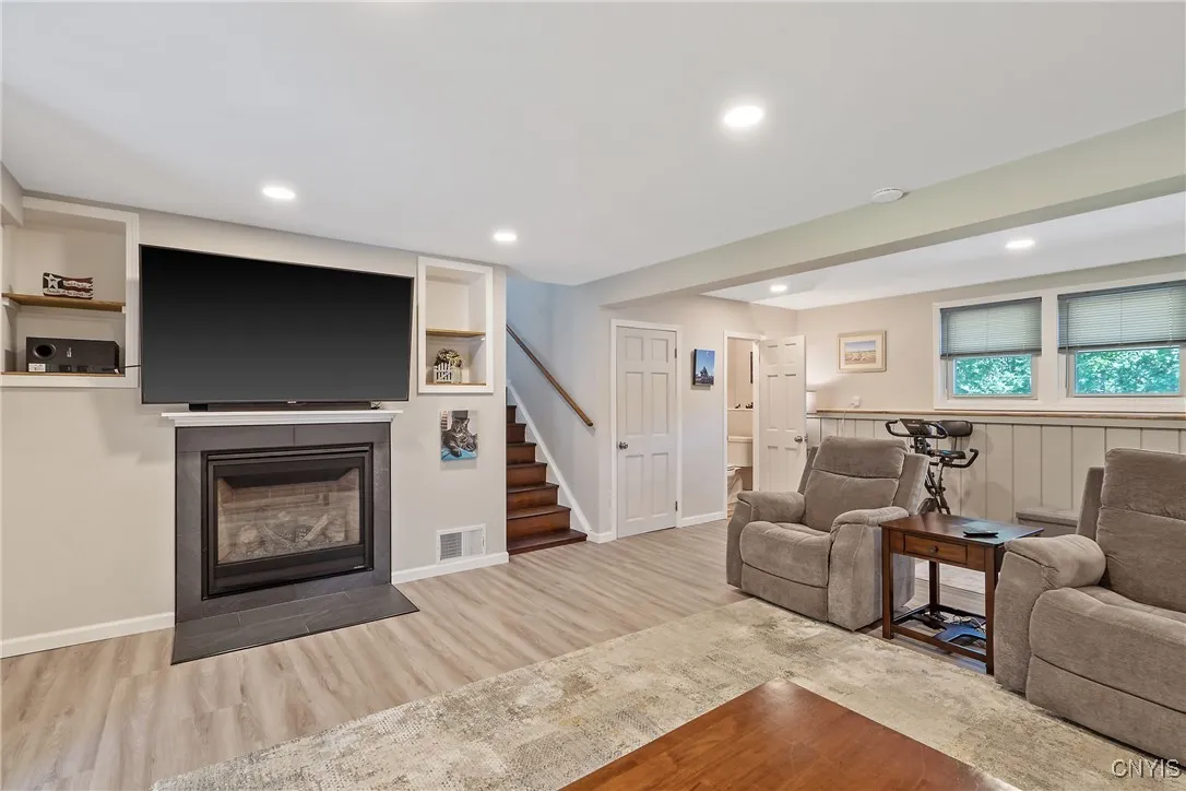 Just a few steps down from the kitchen & living room, you’ll be wowed by this impressively spacious, fully renovated family room—perfect for movie nights, game days, or simply spreading out in style. Stay cozy all winter with the brand-new gas fireplace, and enjoy the charm of built-ins for your favorite photos & décor. Just off this space, you’ll find a conveniently located half bath and a door leading to the lower-level basement.