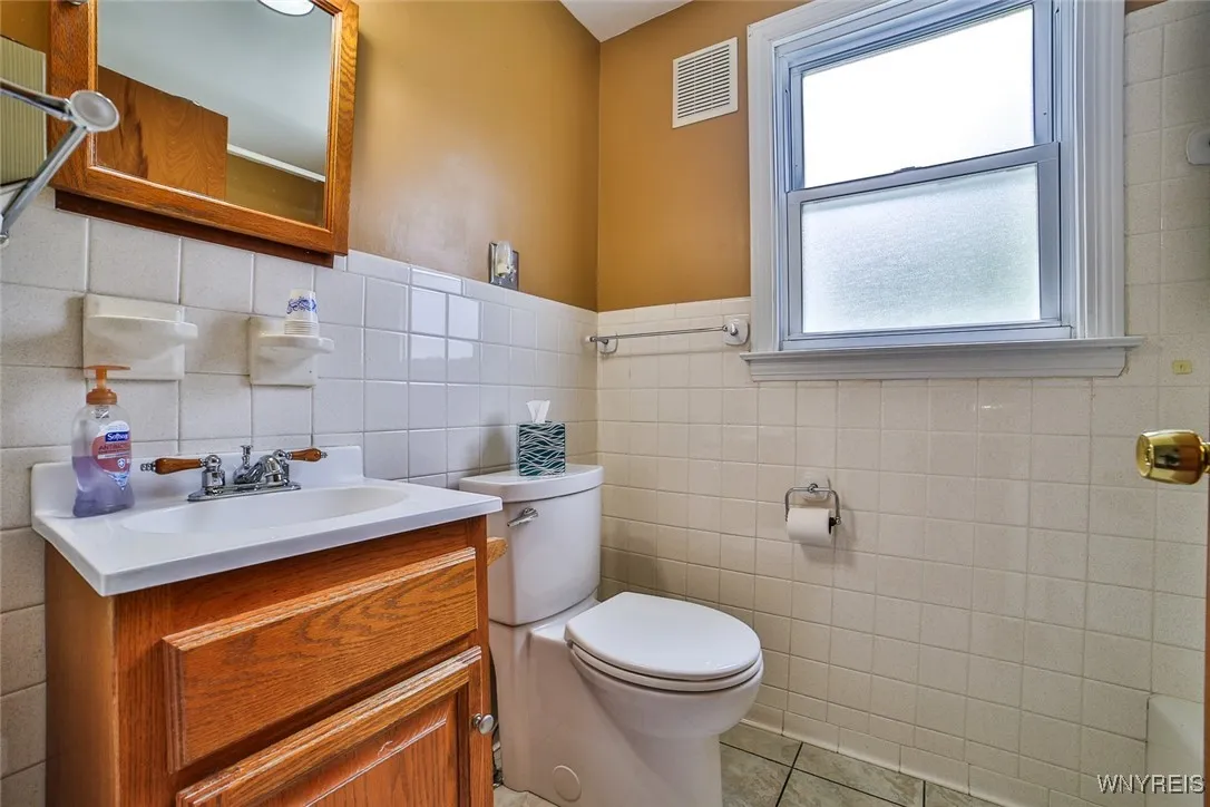The 1st floor bathroom is fresh and bright with neutral ceramic tile.