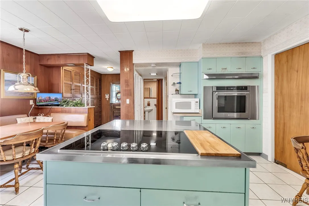 Central island with cooktop, built in oven, loads of cabinet space & adjoining 1/2 bath