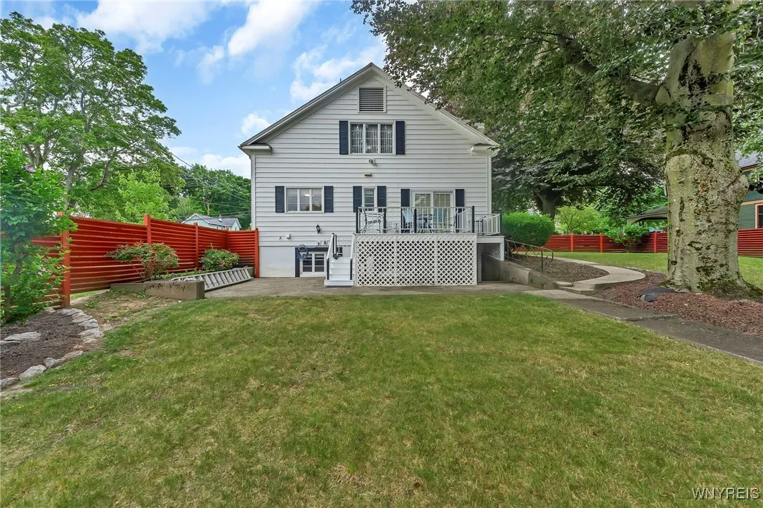 Back of house features deck, concrete patio and direct access to basement