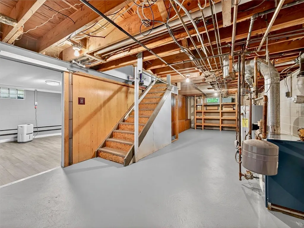 Unfinished area of basement with walk up stairs to the backyard with Bilco doors