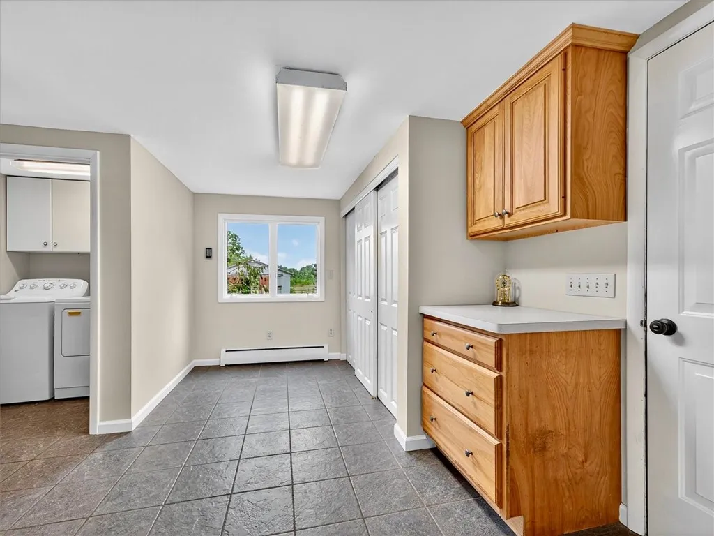 Additional space off the kitchen with entry to garage and large closet. Partial view of first floor laundry