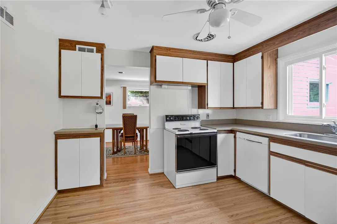 EAT-IN-KITCHEN W/ CORIAN COUNTERS * BOSCH DISHWASHER * ELECTRIC OVENRANGE * REPLACEMENT WINDOW * DEEP SINGLE SS SINK * SAMSUNG REFRIGERATOR * CEILING FAN * HARDWOOD FLOORING