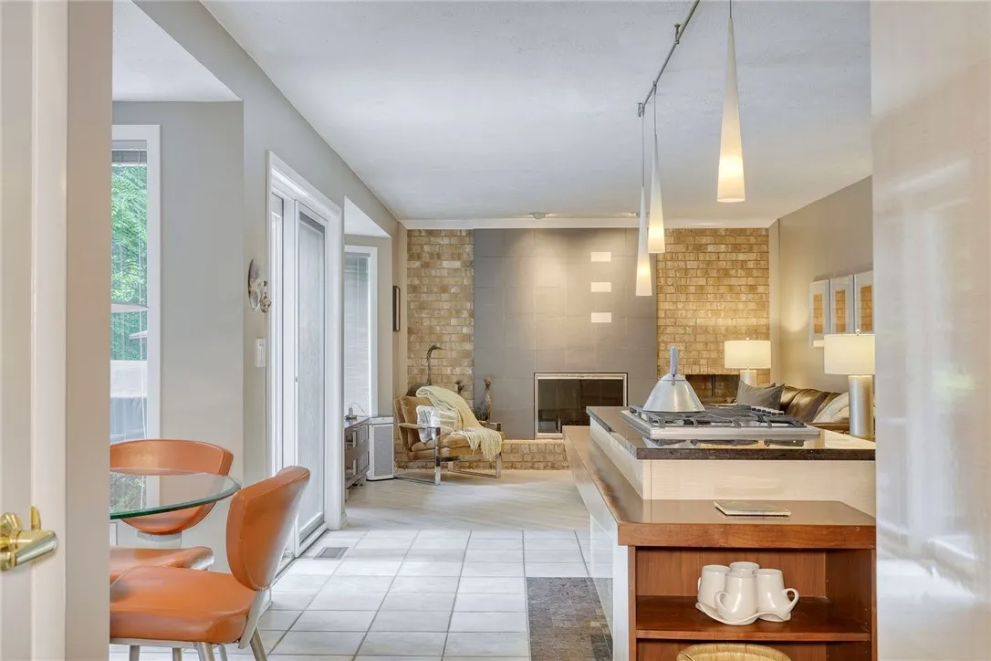 UPDATED DESIGNER KITCHEN with statement island, gas cooktop, granite counters, tile backsplash, quality cabinetry, and bright eat-in nook overlooking backyard.