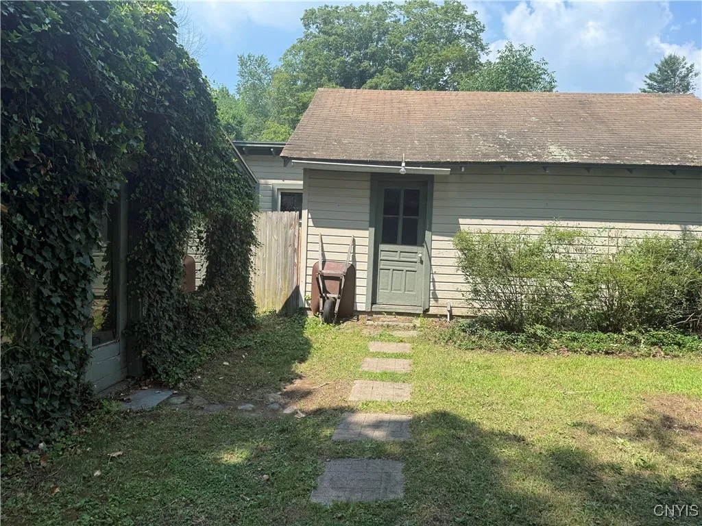 Side view of the house coming from the garage. Another larger enclosed porch entry on the opposite side of the home.