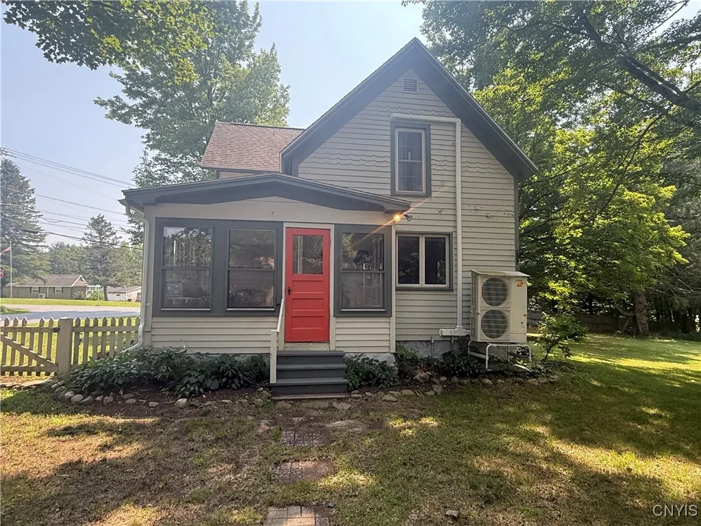 Side view of the house coming from the garage. Another larger enclosed porch entry on the opposite side of the home.
