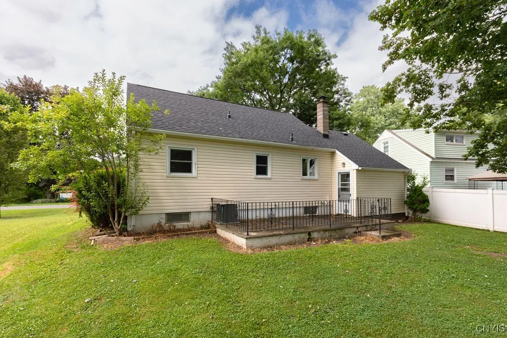 This closer look at the back of the house shows the concrete patio and back door leading into the garage.