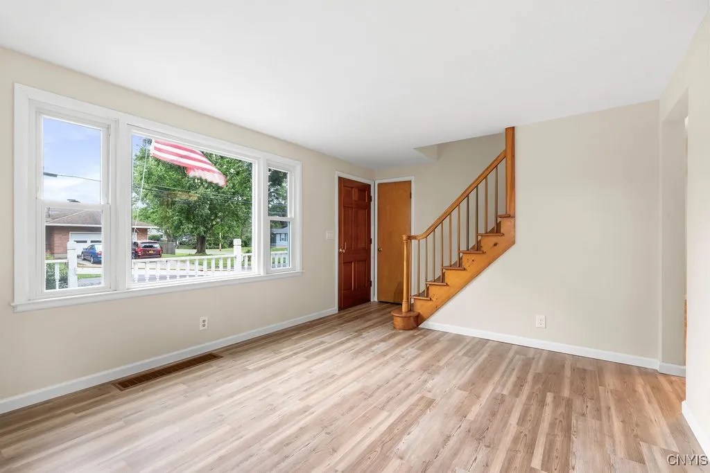 The wide picture window allow plenty of natural light and a view of the pleasant neighborhood.   The front door and coat closet door are pictured here.