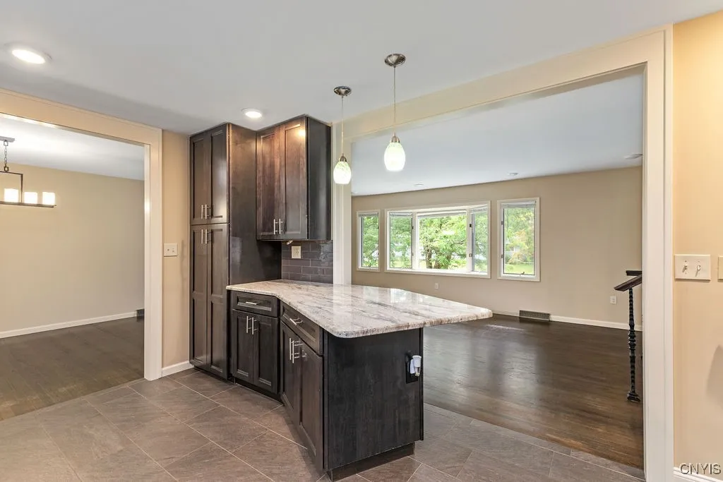 This view of the long pantry cupboard and extended breakfast bar shows added workspace for meal preparation.  The dining room is to the left in this photograph.