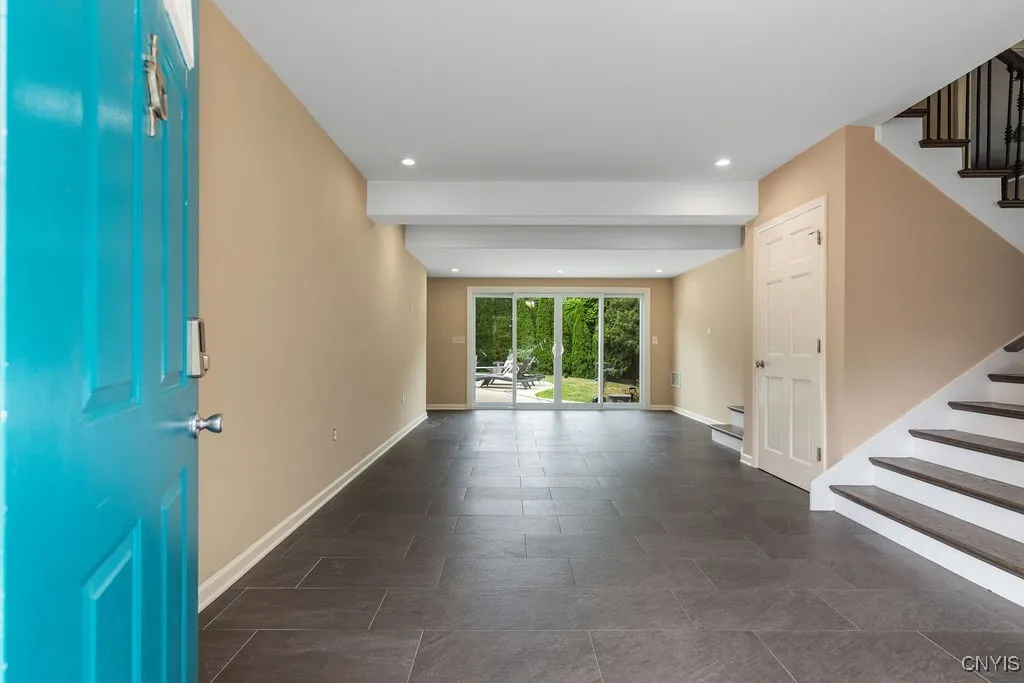 ...a huge entry foyer with room for furniture, a mudroom area, stairs to the living room and kitchen, and the closed door leads to the lower level family room and laundry area.  This is truly flexible space that will make the house function better no matter what the weather does!  The sliding glass doors lead to the spacious back yard with a hot tub, inground salt water swimming pool, and a fully fenced yard.